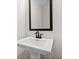 Powder room with pedestal sink and framed mirror at 2780 Marie Way, Cumming, GA 30028