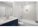 Bathroom with navy blue vanity, shower/tub combo, and mirror at 2735 Marie Way, Cumming, GA 30028