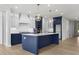 Spacious kitchen with a large island, stylish light fixtures, and a mix of white and blue cabinets at 2735 Marie Way, Cumming, GA 30028