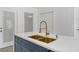 A kitchen island features white countertops, a gold faucet, and navy blue cabinets with gold hardware at 2067 Arlington Nw Cir, Atlanta, GA 30318