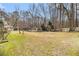 Large grassy backyard with mature trees, swimming pool, and wooded perimeter at 112 Christopher Ln, Stockbridge, GA 30281