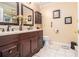 Bathroom featuring a double vanity with dark cabinets, tile floors, and decorative mirrors at 112 Christopher Ln, Stockbridge, GA 30281