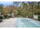 Covered pool with pump, surrounded by patio, lush greenery, and a partial wooden fence at 112 Christopher Ln, Stockbridge, GA 30281