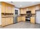 Kitchen with light wood cabinets, granite countertops, and stainless steel appliances at 1852 Red Rose Ln, Loganville, GA 30052