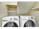 Laundry room with Samsung washer and dryer and additional shelving at 1852 Red Rose Ln, Loganville, GA 30052