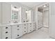 Elegant bathroom with double sinks, white cabinets, and a view into the walk-in shower and linen closet at 220 Spring Branch Dr, Canton, GA 30115