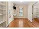 Bedroom with hardwood floors, a built-in desk, a window, and access to a bathroom and a walk-in closet at 220 Spring Branch Dr, Canton, GA 30115