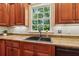 Custom kitchen detail featuring granite countertops, a dark sink, and beautiful wood cabinets at 220 Spring Branch Dr, Canton, GA 30115