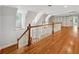 Open loft featuring hardwood floors, built-in shelves, and a view of the staircase with wood and white railing at 220 Spring Branch Dr, Canton, GA 30115