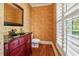 Stylish powder room with red vanity, decorative wallpaper and hardwood floors at 220 Spring Branch Dr, Canton, GA 30115