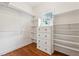 Walk-in closet with custom built-in shelving and drawers for organization and window for natural light at 220 Spring Branch Dr, Canton, GA 30115