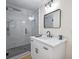 Bathroom featuring a glass shower with a marble tile wall, black accents, and a marble countertop sink at 1830 Mayfield Rd, Alpharetta, GA 30009