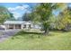 Charming single-story home featuring a carport, manicured lawn, and freshly painted white exterior at 1830 Mayfield Rd, Alpharetta, GA 30009