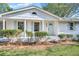 Close up of the freshly painted white home featuring light blue shutters, manicured bushes, and glass front door at 1830 Mayfield Rd, Alpharetta, GA 30009