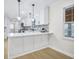 White kitchen with gray brick backsplash, breakfast bar, pendant lights, and stainless steel appliances at 1830 Mayfield Rd, Alpharetta, GA 30009