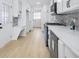 A beautifully remodeled kitchen featuring white cabinets, a stainless steel dishwasher, and light wood-colored floors at 1830 Mayfield Rd, Alpharetta, GA 30009