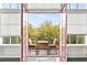 Balcony features a table and chairs with a view of the outdoor scenery through red-framed windows at 572 Edgewood Ne Ave # 306, Atlanta, GA 30312