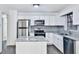 Kitchen with stainless steel appliances, granite countertops, an island, and white cabinets at 570 Harris Sw Ct, Marietta, GA 30060