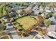 Aerial view showcases a well-maintained green space surrounded by manicured hedges, trees, and residential streets at 3213 Blackley Old, Douglasville, GA 30135