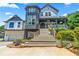 A modern farmhouse style home with gray and white exterior, a large front porch and stairs at 695 Old Peachtree Rd, Lawrenceville, GA 30043