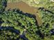Aerial view showing house nestled in a wooded lot near a pond at 100 Lakeside Dr, Covington, GA 30016