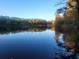 Serene lake view with tranquil waters and lush autumn foliage at 100 Lakeside Dr, Covington, GA 30016