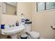 Quaint bathroom featuring a pedestal sink, toilet, vanity mirror, and a bright window at 1236 Country Pine Dr, Ellenwood, GA 30294