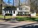 Lovely white home featuring black shutters, a well-manicured lawn, and a tidy walkway to the front door at 1236 Country Pine Dr, Ellenwood, GA 30294