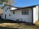 Side view of a white brick home showcasing the well-maintained yard and neutral color scheme at 1236 Country Pine Dr, Ellenwood, GA 30294
