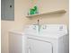 Functional laundry area equipped with a washer and dryer, plus a shelf for organized storage at 1236 Country Pine Dr, Ellenwood, GA 30294