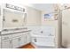 Bathroom with white cabinet, tub, and shower features a large mirror at 160 Cross Rd, Covington, GA 30016