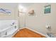 Bathroom with tub and shower combination features tile floors and is decorated with ocean-themed art at 160 Cross Rd, Covington, GA 30016