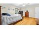 Bedroom with wood floor features ceiling fan, wooden bed frame, dresser, and closet space at 160 Cross Rd, Covington, GA 30016