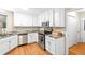 Bright kitchen featuring white cabinets, stainless steel appliances, and hardwood flooring at 160 Cross Rd, Covington, GA 30016