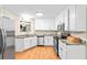 Bright kitchen with white cabinets, stainless steel appliances, and wood flooring at 160 Cross Rd, Covington, GA 30016