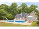 Back of home view of a beautiful inground pool with basketball hoop, slide, and surrounding patio at 160 Cross Rd, Covington, GA 30016