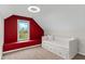 Bright bedroom with a red accent wall and a built-in daybed with storage drawers at 2941 Lookout Ne Pl, Atlanta, GA 30305