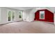 Expansive bonus room featuring neutral carpeting, natural light, and a charming red accent wall at 2941 Lookout Ne Pl, Atlanta, GA 30305