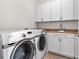 Well-equipped laundry room with modern washer, dryer, sink, and ample cabinet storage at 2941 Lookout Ne Pl, Atlanta, GA 30305