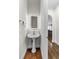 Powder room with pedestal sink, illuminated mirror, and hardwood floors at 2941 Lookout Ne Pl, Atlanta, GA 30305