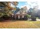 Charming brick home with manicured landscaping and a basketball hoop in the driveway at 210 Huiet Dr, Mcdonough, GA 30252
