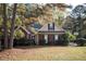 Charming red brick home with manicured landscaping and a basketball hoop in the driveway at 210 Huiet Dr, Mcdonough, GA 30252