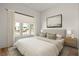 Comfortable bedroom featuring a window, artwork, wood floors, and neutral toned decor at 10939 Serenbe Ln, Chattahoochee Hills, GA 30268