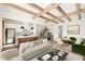 Open-concept living room featuring wood beams, hardwood floors, dining area, and modern kitchen with island at 10939 Serenbe Ln, Chattahoochee Hills, GA 30268