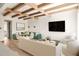 Comfortable living room area with wood beams, modern lighting, and large screen tv at 10939 Serenbe Ln, Chattahoochee Hills, GA 30268