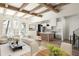 Bright, open-concept living room featuring wood beams, hardwood floors, and modern kitchen with island at 10939 Serenbe Ln, Chattahoochee Hills, GA 30268