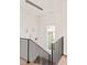 Modern staircase with geometric pendant lighting and black metal railing at 10939 Serenbe Ln, Chattahoochee Hills, GA 30268