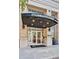 Museum Tower entrance featuring glass doors, brick facade, and covered awning, adding an inviting architectural statement at 285 Centennial Olympic Park Nw Dr # 903, Atlanta, GA 30313