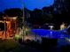 Backyard pool area at night, featuring a slide and a diving board surrounded by a dark fence at 424 Lake Point Trce, Canton, GA 30114