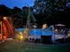Backyard pool area at night featuring a slide, umbrellas, and a dark surrounding fence at 424 Lake Point Trce, Canton, GA 30114